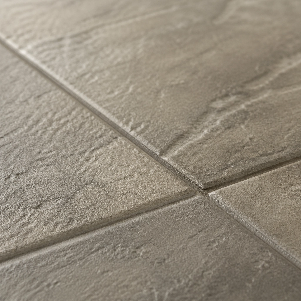 Macro shot of a COREtec VV870 tile showing the realistic stone surface and integrated bevel edge.